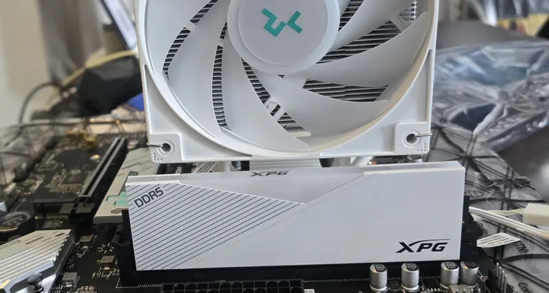 White XPG DDR5 memory installed beside a white tower CPU cooler